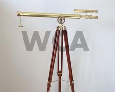 an old telescope on a tripod with wooden stand and brass plated metal fittings