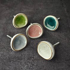 four different colored bowls sitting on top of a table