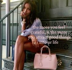 a woman is sitting on the steps with her hand in her mouth and holding a pink purse