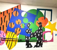 a colorful mural on the wall of a school hallway with black and white polka dots