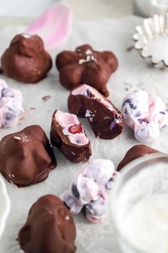 chocolate covered desserts are sitting on a table next to a glass of milk and utensils