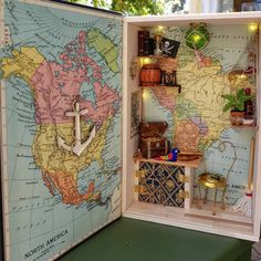 the inside of a dollhouse with a map and other things on display in it