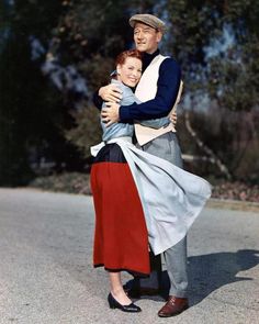 a man and woman hugging each other on the street