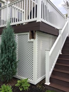 a white deck with trellis on the side and stairs leading up to an upper level