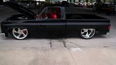 a black truck with chrome rims parked in a parking lot