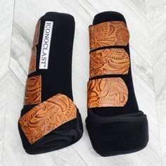 a pair of black and brown sandals on top of a white wooden floor next to each other