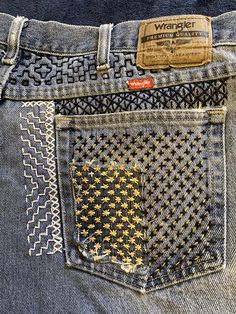 the back pocket of a pair of blue jeans with gold stars on it and a tag