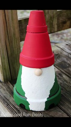 a plastic santa hat sitting on top of a wooden table next to a wood fence