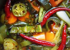 a pot filled with lots of different types of veggies and sauce on top of it