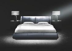 a black and white photo of a bed with two lamps on either side of it