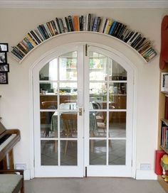 a living room filled with furniture and a book shelf next to a white front door