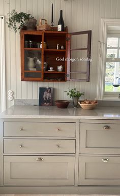 a kitchen with white cabinets and wooden shelves