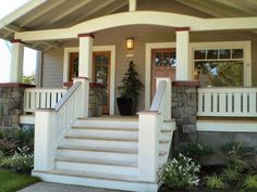 the front porch of a house with steps leading up to it and potted plants on either side