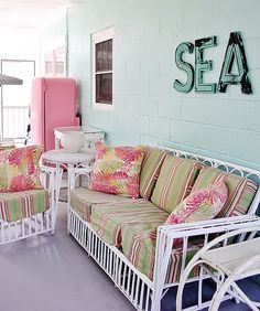 a living room filled with furniture next to a pink refrigerator