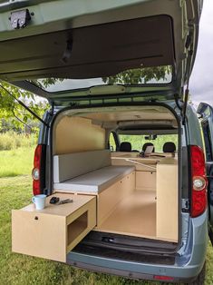 the back end of a van with an open hatchback and storage compartment in it