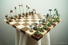 a chess board with flowers and plants on it, as if they were made out of wood