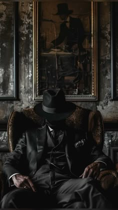 a man sitting in a chair with a hat on his head, wearing a suit and tie