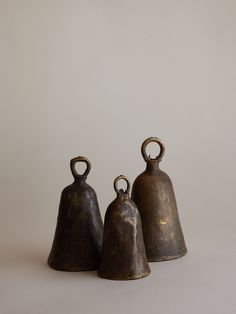 three bronze bells sitting next to each other