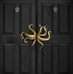 an octopus door knocker on the front of a black door with gold foiling