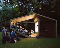 people are sitting on the steps in front of an open air structure at night time