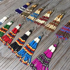 many different colored tassels are laid out on a wooden floor and ready to be sold