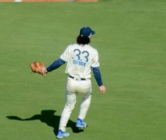 a baseball player standing on top of a field holding a catcher's mitt