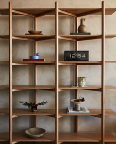 a wooden shelf filled with books and vases