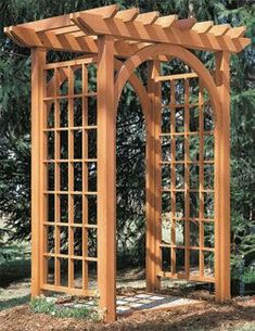 a wooden arbor in the middle of a yard with trees behind it and bushes to the side