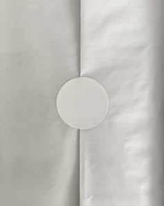 a white plate sitting on top of a table next to some sheets of silver paper