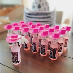 many bottles with pink caps are lined up on a table