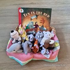 there are many stuffed animals in the basket on the table with it's book