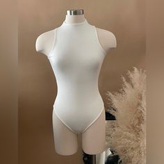 Our Romy Sleeveless Racerback Bodysuit Is Double Lined. It Features A Mock Neck And A Snap Button Closure Bottom. Fabric 96% Rayon Modal 4% Spandex Color: White White Stretch Racerback Bodysuit, Fitted White Tank Bodysuit, White Fitted Tank Bodysuit, Stretch Racerback Bodysuit, White Fitted Sleeveless Bodysuit, White Racerback Bodysuit For Summer, Elegant White Sleeveless Bodysuit, Sleeveless Bodysuit For Spring, White Stretch Backless Tank Top