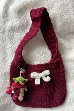 a crocheted bag with a small stuffed animal hanging from it's side