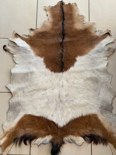 a brown and white cowhide rug on the floor