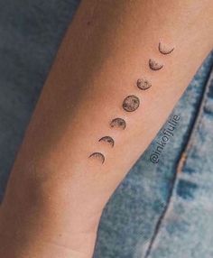 a woman's arm with three phases of the moon on it