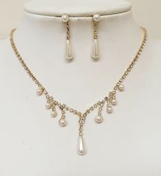 a necklace and earring set with pearls on a mannequin neckline,