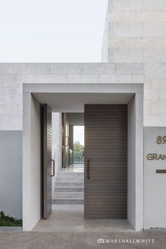 an entrance to a building with stairs leading up to it and a wooden door in the middle