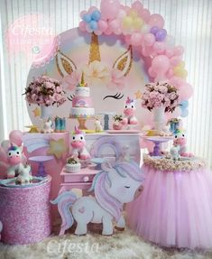 a birthday party with pink and blue balloons, unicorns, and other decorations on the table