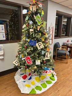 a decorated christmas tree in the middle of an office cubicle with letters and numbers on it