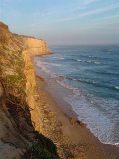 the beach is next to an ocean cliff