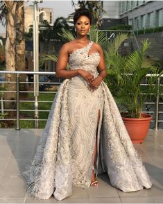 a woman in a white gown posing for the camera