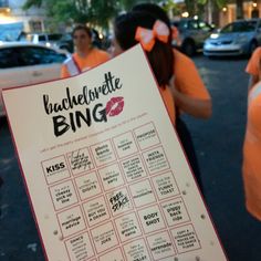 a woman holding up a sign with the words bachelor bing on it in front of other people