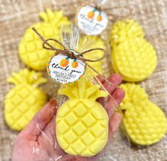 small pineapples are wrapped in cellophane and tied with twine