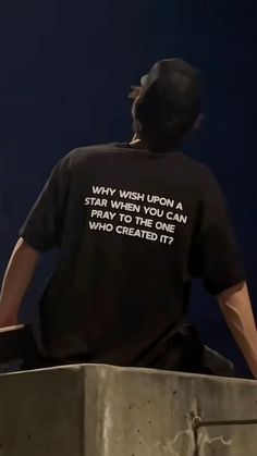 a man sitting on top of a cement block with his back to the camera, wearing a black t - shirt that says way wish upon a star wars you can pray to those who created it