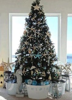 a decorated christmas tree with starfish and seashells in the center is surrounded by other holiday decorations