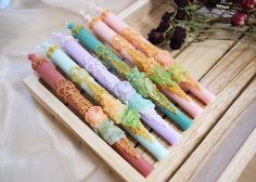 several candles are lined up on a wooden tray