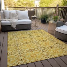 a yellow area rug sitting on top of a wooden deck next to two chairs and a couch