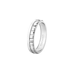 a white gold wedding ring with roman numerals on the outside and an engraved design