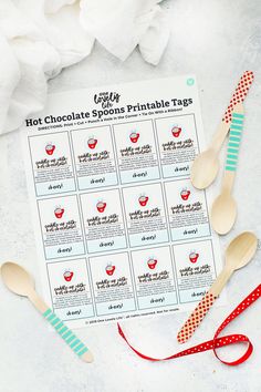 the hot chocolate spoons printable tags are lined up on a table