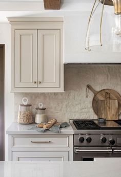 a kitchen with an oven, stove and counter top in the middle of it's white cabinetry